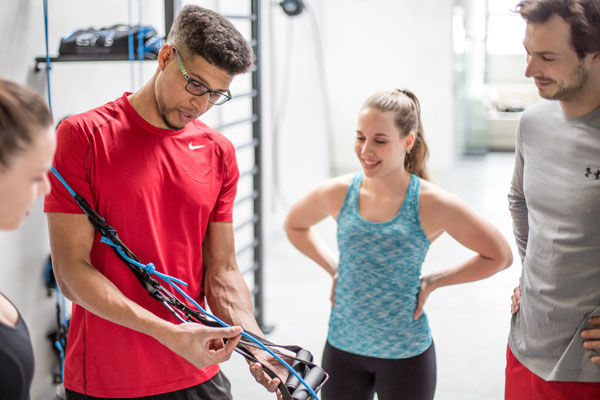 PT showing clients how to use fitness equipment