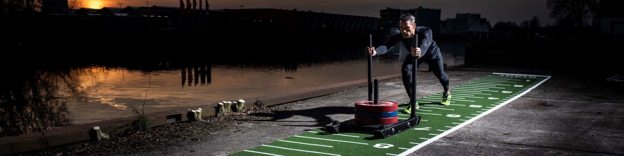 Man pushing sled on gym flooring