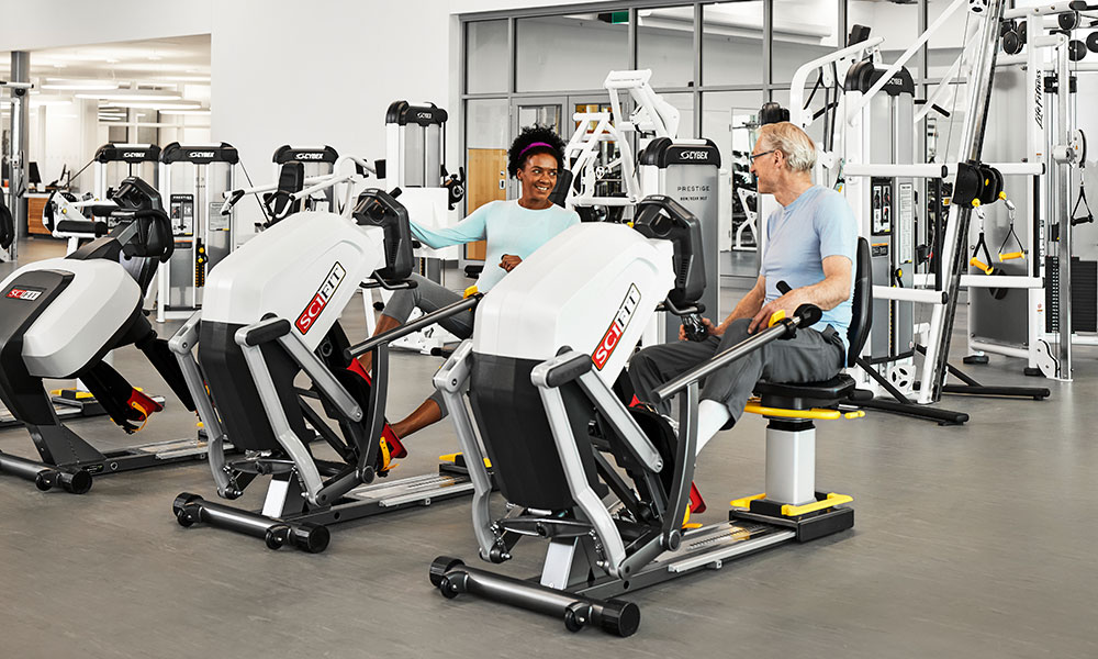 Man and woman using weight machines for rehab